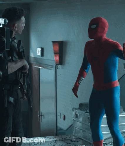 A Man In A Spiderman Costume Stands Next To A Man In A Black Suit GIF