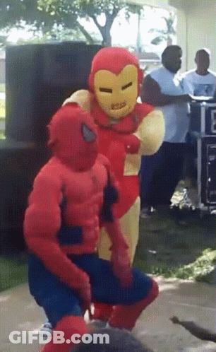 A Man In A Spiderman Costume Stands Next To A Man In An Ironman Costume GIF