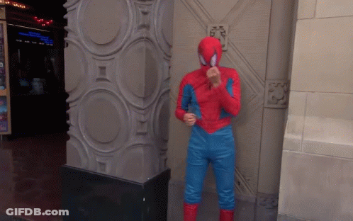A Man In A Spiderman Costume Stands Next To A Pillar GIF