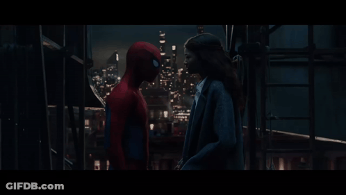 A Man In A Spiderman Costume Stands Next To A Woman In A Suit GIF