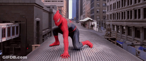 A Man In A Spiderman Suit Is Crawling On A Roof GIF