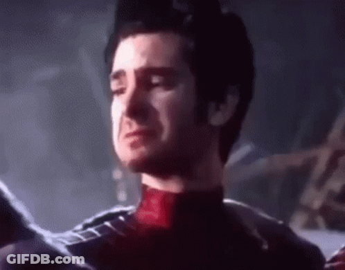 A Man In A Spiderman Suit Is Crying With His Eyes Closed In A Dark Room . GIF