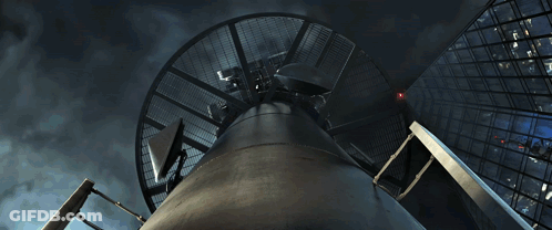 A Man In A Spiderman Suit Is Fighting A Dinosaur GIF
