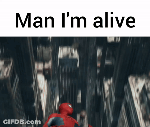 A Man In A Spiderman Suit Is Flying Through The Air With The Words Man I 'M Alive GIF