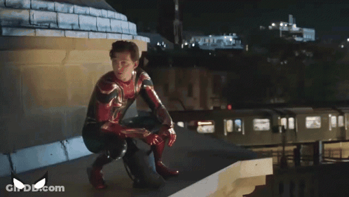 A Man In A Spiderman Suit Sits On A Sidewalk GIF