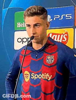 A Man In A Spotify Shirt Is Standing In Front Of A Microphone . GIF