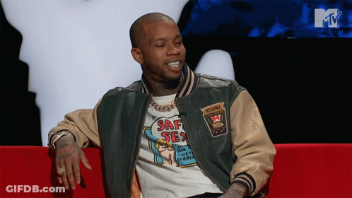 A Man In A Srf Sex Shirt Sits On A Couch GIF