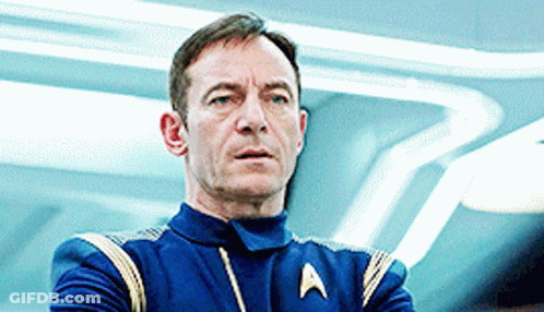 A Man In A Star Trek Uniform Is Looking At Something GIF