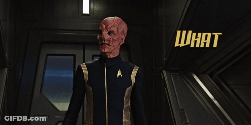 A Man In A Star Trek Uniform Is Standing In A Hallway With The Words What Is It You So Urgently Need My Help With GIF