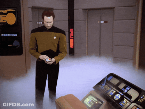 A Man In A Star Trek Uniform Is Standing In A Room With A Sign That Says Eo On It GIF