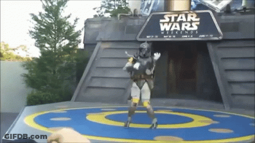 A Man In A Star Wars Costume Is Standing In Front Of A Sign That Says Star Wars Weekends GIF