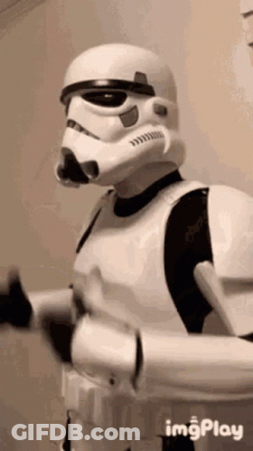 A Man In A Storm Trooper Costume Is Standing In A Room . GIF