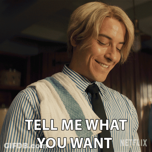 A Man In A Striped Shirt And Tie Is Smiling And Saying Tell Me What You Want GIF
