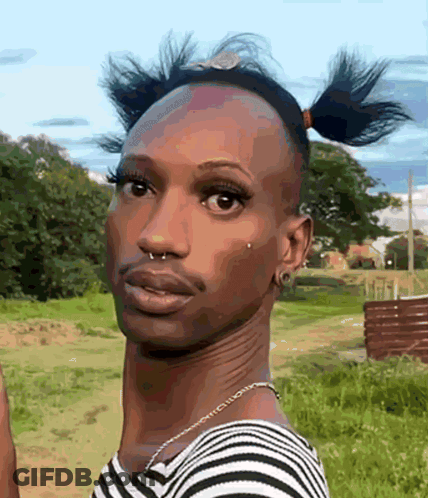 A Man In A Striped Shirt Has A Nose Ring And A Necklace Around His Neck GIF