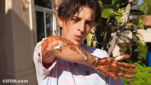 A Man In A Striped Shirt Has His Hands Covered In Chocolate GIF