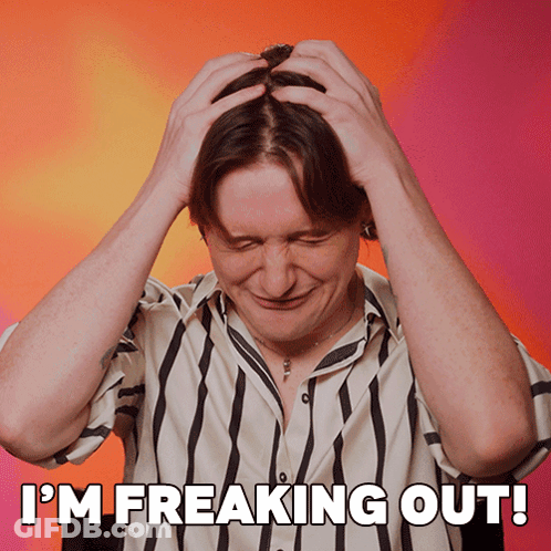A Man In A Striped Shirt Has His Hands On His Head And The Words I 'M Freaking Out Above Him GIF