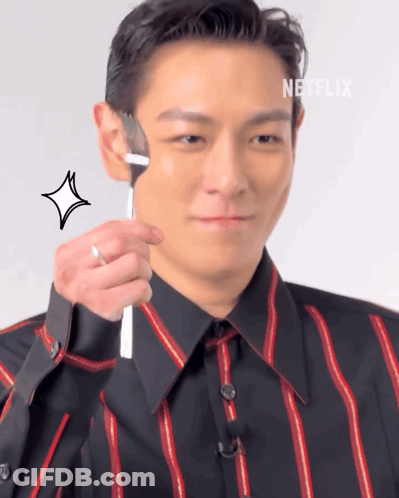 A Man In A Striped Shirt Holds A Fork To His Face GIF