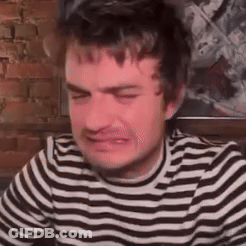 A Man In A Striped Shirt Is Crying And Making A Funny Face . GIF