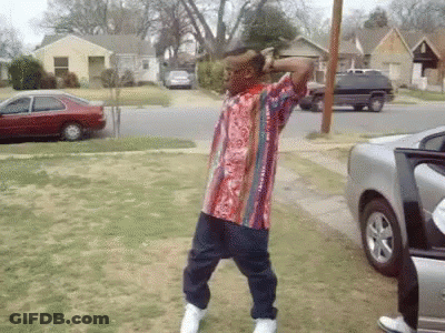 A Man In A Striped Shirt Is Dancing In Front Of A Car GIF