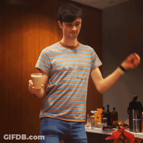 A Man In A Striped Shirt Is Holding A Cone GIF
