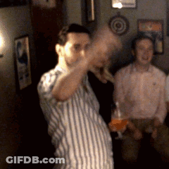 A Man In A Striped Shirt Is Holding A Glass GIF