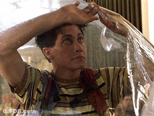 A Man In A Striped Shirt Is Holding A Plastic Bag Over His Head And Water Is Coming Out Of It GIF