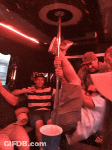 A Man In A Striped Shirt Is Holding A Pole In A Red Room GIF