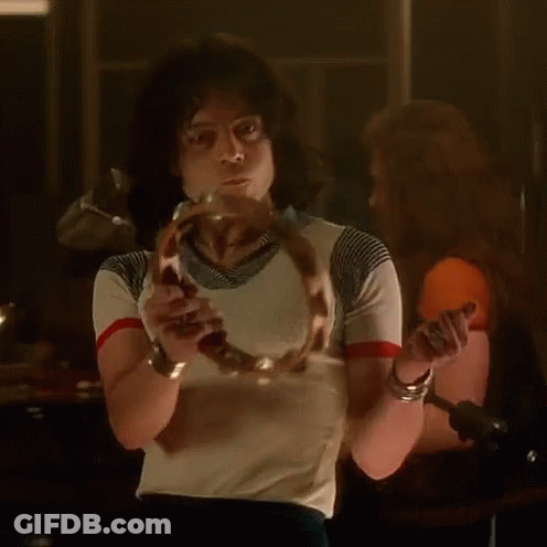 A Man In A Striped Shirt Is Holding A Snake In His Hand GIF