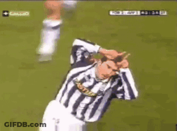 A Man In A Striped Shirt Is Kneeling Down On A Field GIF