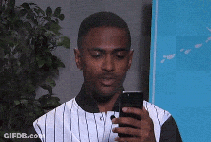 Man In Striped Shirt Looking At Cell Phone GIF