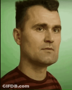 A Man In A Striped Shirt Is Looking At The Camera GIF