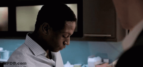 A Man In A Striped Shirt Is Looking Down GIF