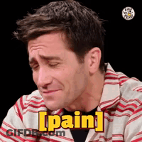 A Man In A Striped Shirt Is Making A Face And Saying Pain . GIF