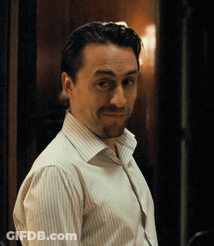 A Man In A Striped Shirt Is Making A Face GIF