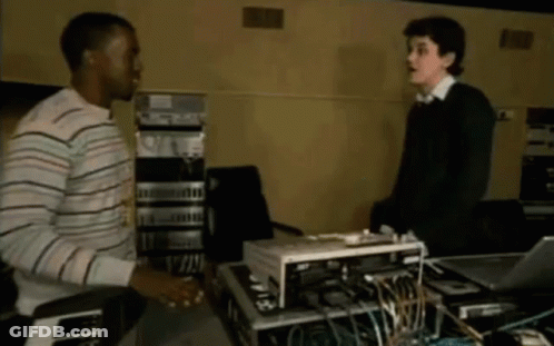 Man In Striped Shirt Shaking Hands With Man In Black Sweater GIF