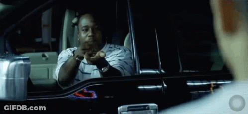 A Man In A Striped Shirt Is Sitting In A Car And Looking Out The Window GIF