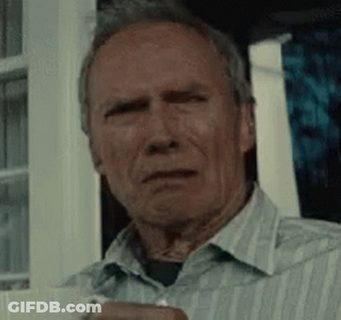 A Man In A Striped Shirt Is Sitting In Front Of A Window Holding A Cup . GIF
