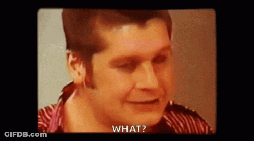 A Man In A Striped Shirt Is Smiling And Saying `` What '' . GIF