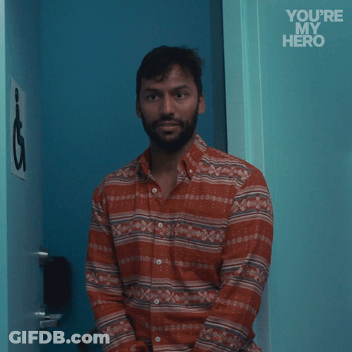 A Man In A Striped Shirt Stands In Front Of A Blue Door With The Words " You 'Re My Hero " Written On It GIF