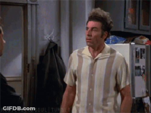 A Man In A Striped Shirt Stands In Front Of A Fridge GIF