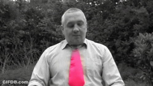 A Man In A Striped Shirt With A Pink Tie GIF