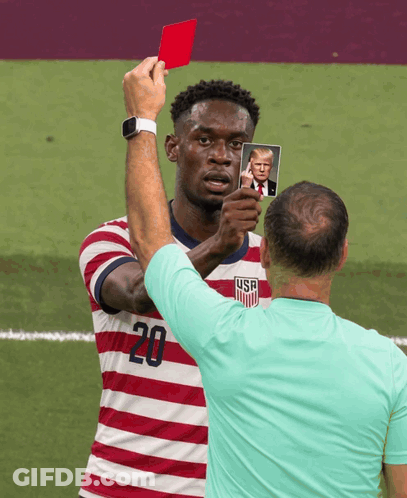 A Man In A Striped Shirt With The Number 20 On It Holds Up A Picture Of Donald Trump GIF