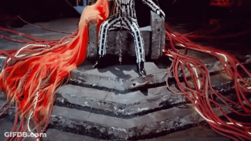 A Man In A Striped Suit Is Sitting On A Throne GIF