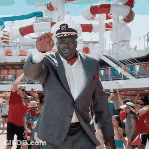 A Man In A Suit And A Captain 'S Hat Is Waving GIF