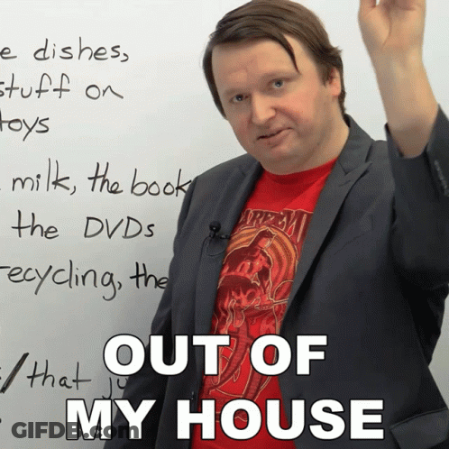 A Man In A Suit And A Red Shirt Stands In Front Of A White Board That Says " Out Of My House " GIF