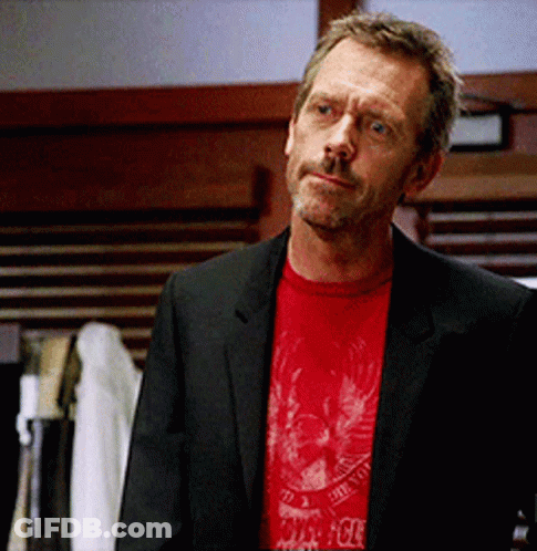 A Man In A Suit And A Red T-Shirt With A Skull And Crossbones On It GIF