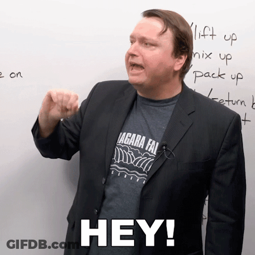 A Man In A Suit And A Shirt That Says " Hey " On It GIF