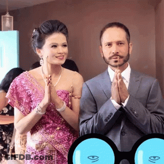 A Man In A Suit And A Woman In A Pink Dress Praying GIF