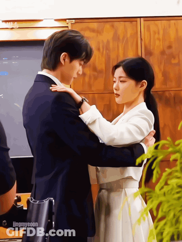 A Man In A Suit And A Woman In A White Dress Are Hugging Each Other With The Caption Jingmyeeoon GIF