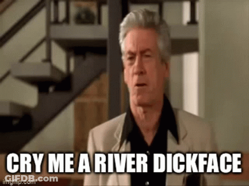 A Man In A Suit And Black Shirt Is Standing In Front Of A Staircase . GIF